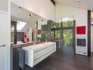 Elegantes Badezimmer mit großen Fenstern und moderner Ausstattung