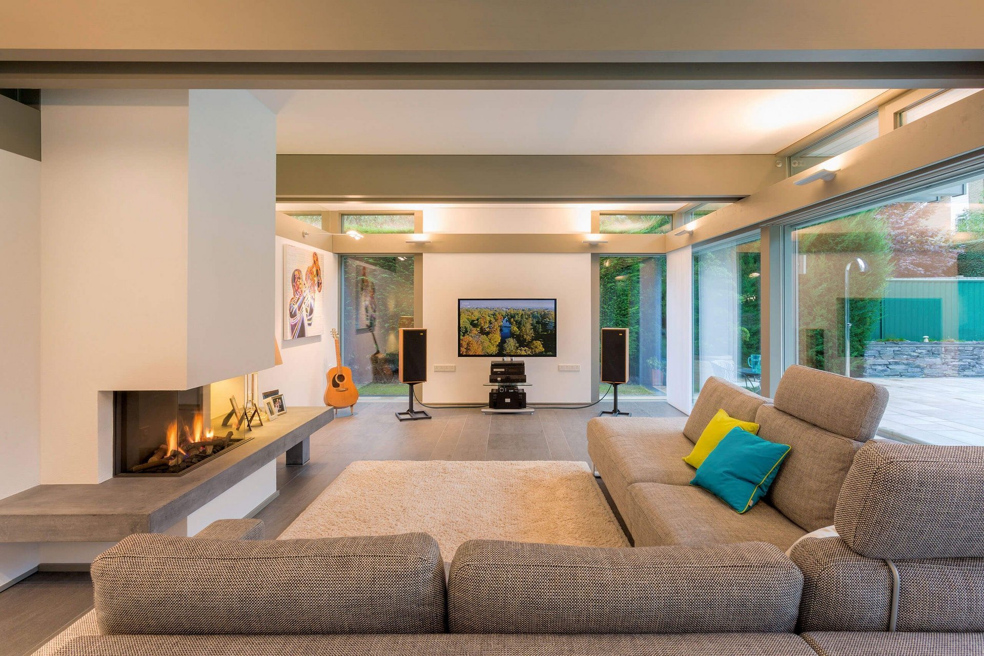Helles Wohnzimmer mit Couch, Kamin, Fernseher und stilvollen Akzenten