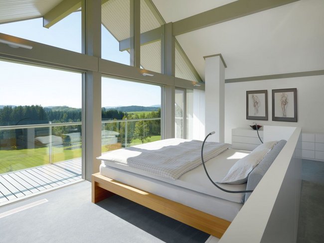 Modernes Schlafzimmer mit Blick auf die Natur Helles Schlafzimmer mit großen Glasfenstern und zeitloser Eleganz