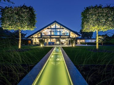Modernes Fachwerkhaus mit Garten und Panorama Transparente Architektur mit Holz und Glas, Garten mit Bachlauf bei Nacht