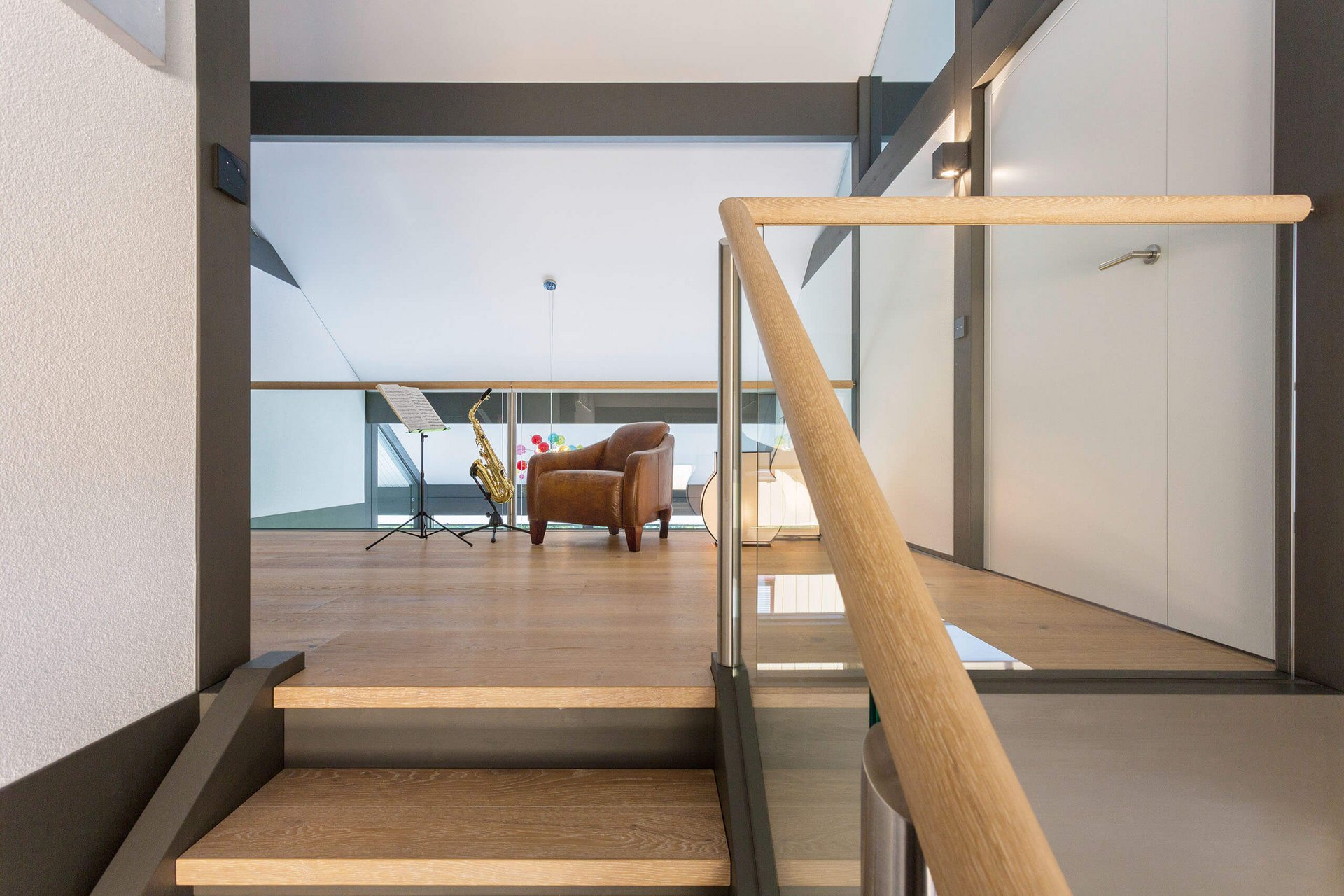 Heller Wohnraum mit Treppe, Sofa und Saxophon-Ständer