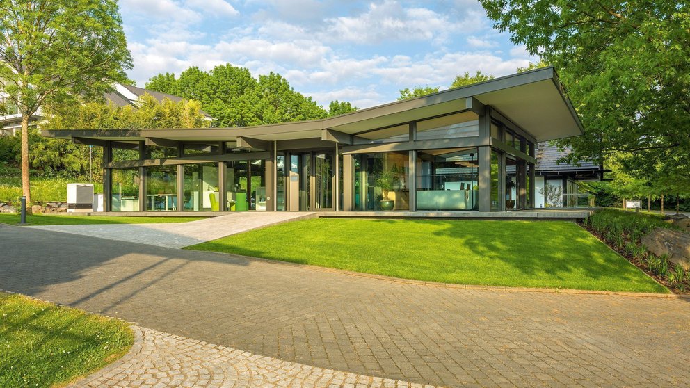 Ein modernes Gebäude mit Glas und Grünflächen in der Nähe