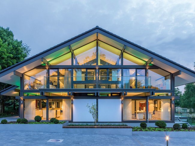 Elegantes, modernes Haus mit großen Fenstern und grünem Umfeld