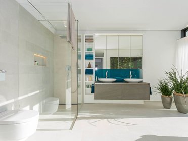 Modernes Badezimmer mit Doppelwaschbecken und Pflanze Helles Badezimmer mit Glasdusche, zwei Waschbecken und modernen Akzenten