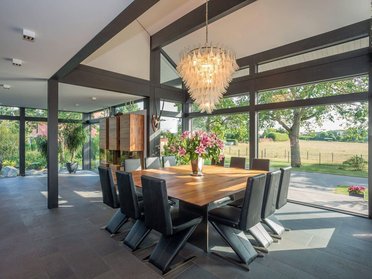 Moderne Architektur mit Essbereich und Blick ins Freie Ein zeitgenössischer Essbereich mit Glasfenstern und stilvoller Einrichtung