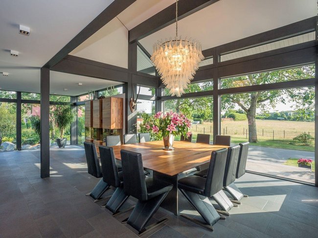 Moderne Architektur mit Essbereich und Blick ins Freie Ein zeitgenössischer Essbereich mit Glasfenstern und stilvoller Einrichtung