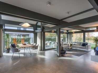 Moderne Wohnräume mit Glaswänden und Pflanzen Helles Wohnzimmer mit Essbereich und modernem Design