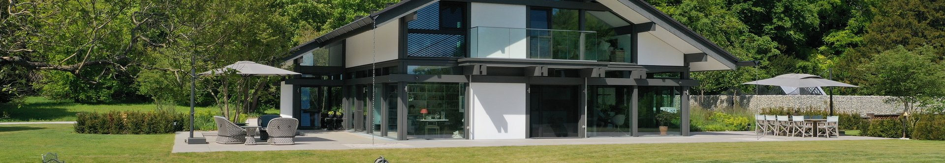 Modernes Gebäude mit grünem Landschaftsdesign Helles, modernes Haus umgeben von Bäumen und einem Teich