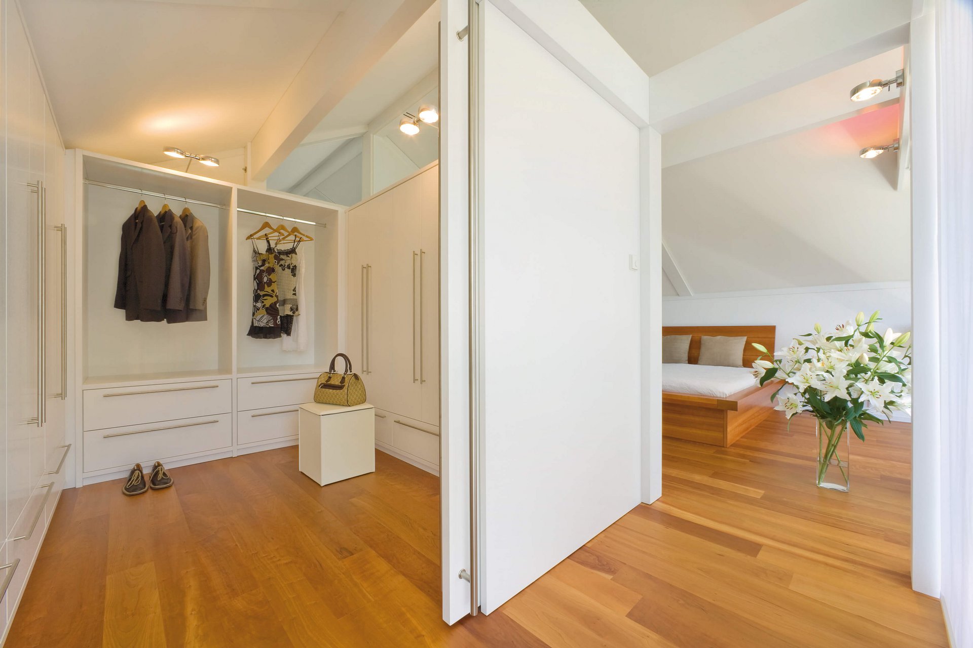 Ein heller Raum mit Kleiderschrank, Holzfußboden und gemütlichem Bett