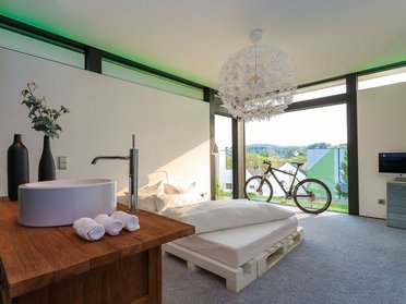 Helles modernes Zimmer mit Bett, Fahrrad und stilvollem Design