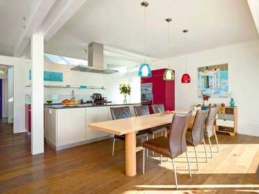 Helle, moderne Küche mit Tisch und bunten Lampen, zeitloses Design