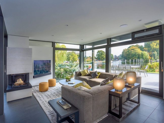 Helle Wohnlandschaft im Luxushaus mit Flachdach und Blick auf den Garten