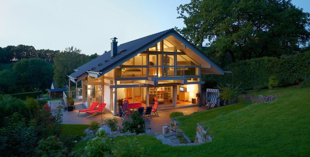 Ein gemütliches modernes Haus bei Dämmerung, umgeben von Natur