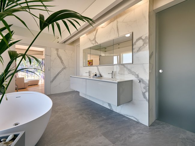 Helles Badezimmer mit Badewanne, Waschbecken und Spiegel