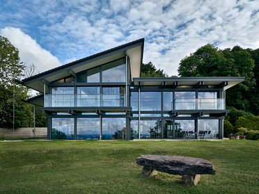 HUF Haus am Meer, modernes Designhaus Futuristisches Designhaus mit Glasfassade und Dachschrägen