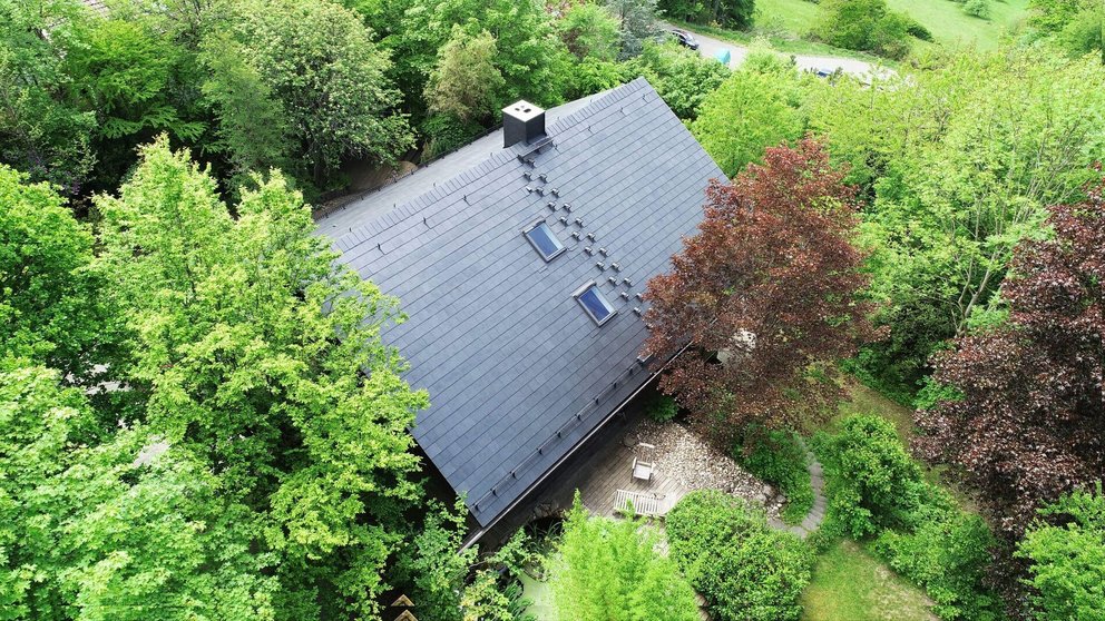 Luftaufnahme eines Hauses mit begrünter Umgebung und Bäumen