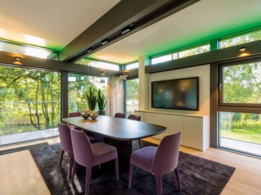 Elegantes Esszimmer mit Pflanzen, TV und Aussicht auf den Garten