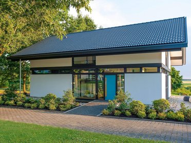 Ein helles, modernes Einfamilienhaus mit begrüntem Garten und Auffahrt