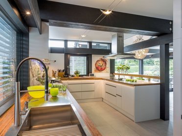 Modernes Kücheninterieur in transparentem Fachwerkhaus Hochwertige Küche in einem stilvollen Holz- und Glashaus