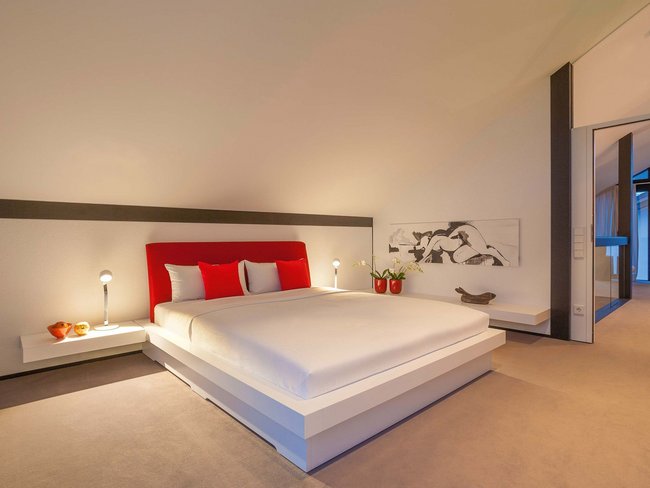 HUF Haus modum 810 Musterhaus Wuppertal 12 Elegantes Schlafzimmer mit rotem Bett und minimalistischer Dekoration