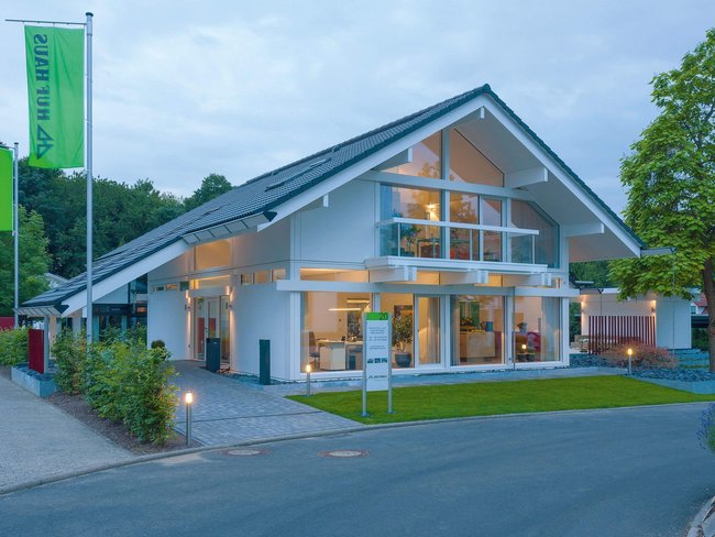 Helles, modernes Haus mit großen Fenstern und Garten.