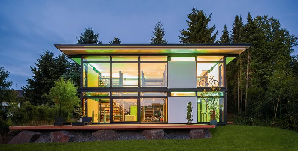 Ein lichtdurchflutetes modernes Haus mit großen Fenstern in der Natur