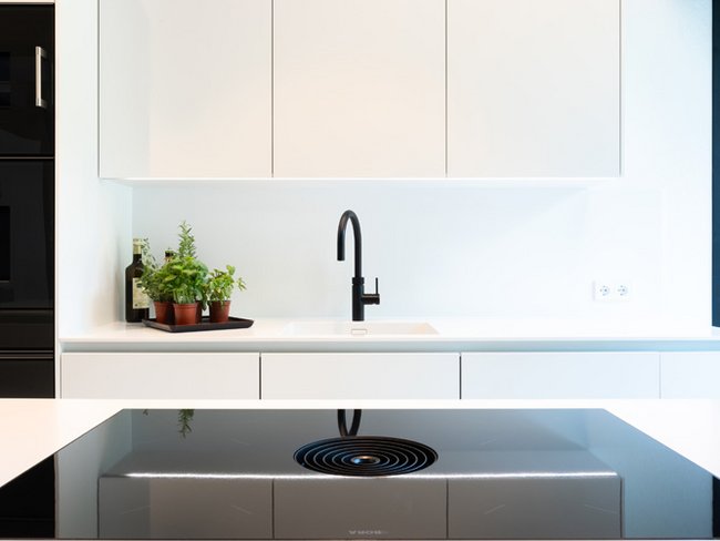 Modernes HUF Bungalow Kücheninterieur Hochmoderne Küche mit minimalistischen weißen Möbeln und Pflanzen