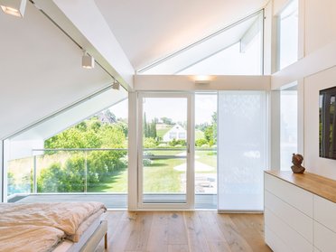 Helles Schlafzimmer im Designhaus mit Balkon und Panoramaansicht