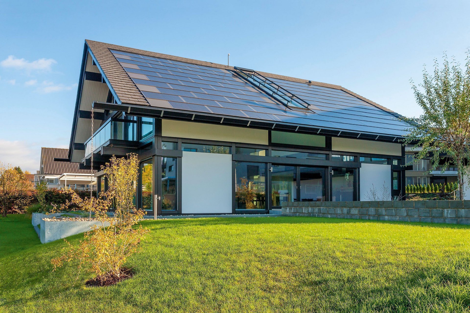 Freistehendes modernes Haus mit großen Fenstern und grünem Rasen