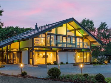 Elegante Architektur umgeben von Bäumen und Gartenbeleuchtung