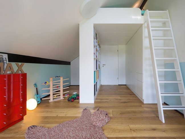 Heller Raum im Familienhaus mit Holzfußboden und moderner Treppe