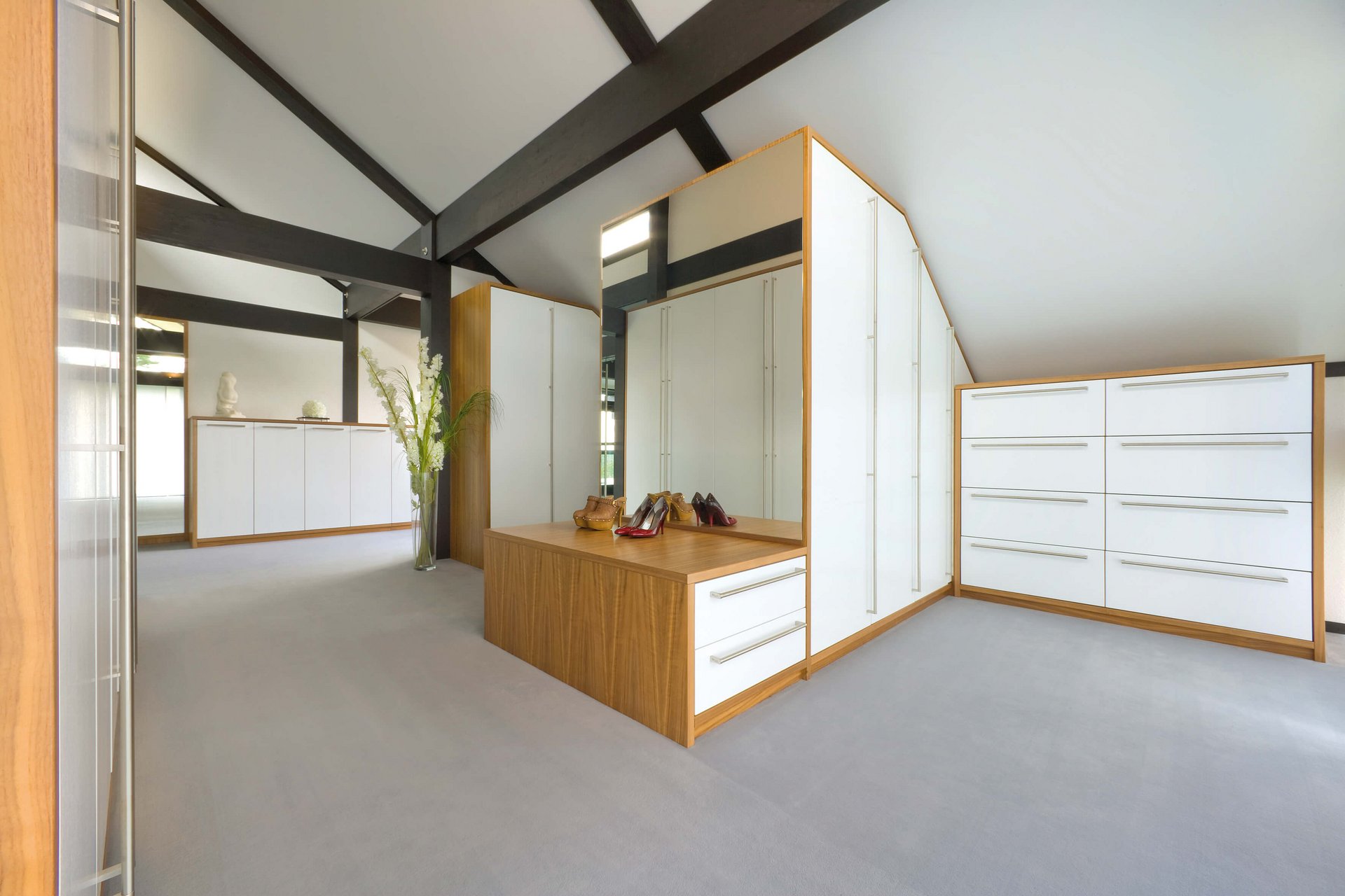 Geräumiger Raum mit eleganten weißen Schränken und Holzdetails