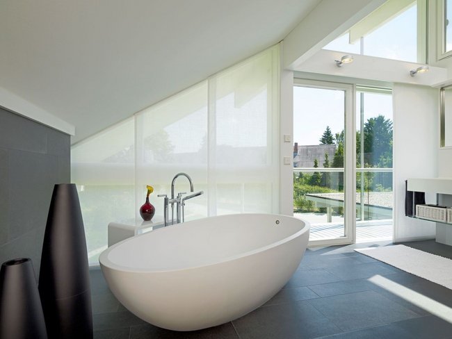 Helles Badezimmer mit freistehender Badewanne und Gartenblick