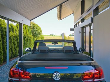 Eine Ansicht eines Architektenhauses mit einem schwarzen Cabrio im Vordergrund