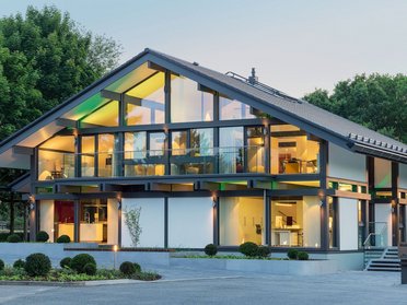 Futuristisches Haus mit Glasfassade und Umgebungsgrün