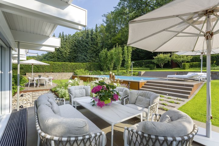 Außenansicht einer Fachwerk-Villa mit schönem Garten und Sitzbereich