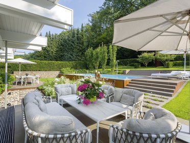 Außenansicht einer Fachwerk-Villa mit schönem Garten und Sitzbereich