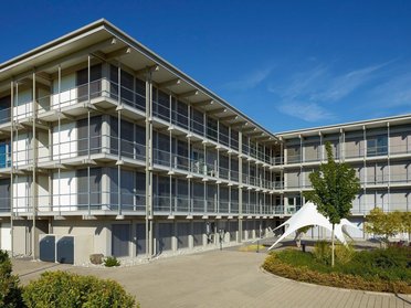 Ansicht eines modernen Bürogebäudes mit Pflanzen und klarem Himmel