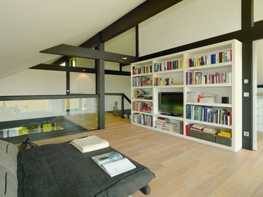 Helles Schlafzimmer mit Bücherregal und moderner Einrichtung