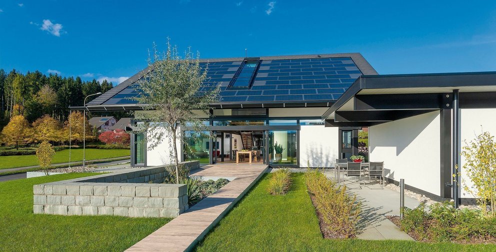 Ansicht eines modernen Hauses mit Solarpanelen und gut gestalteter Landschaft