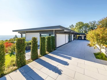 Modernes HUF HAUS mit Flachdach und gepflegtem Garten, klare Linien