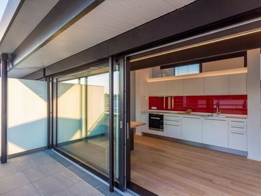 Einblick in eine moderne Küche mit rotem Akzent im Architektenhaus