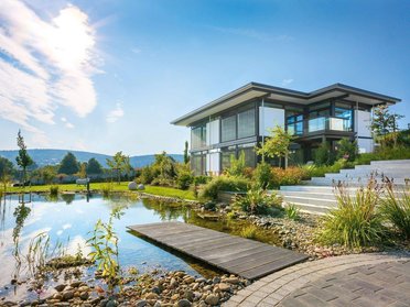 HUF Bürogebäude mit Garten und Wasserlandschaft im Vordergrund