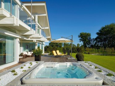 Architektenhaus umgeben von Garten und Whirlpool, harmonisch mit der Natur