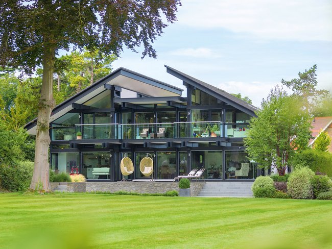 Modernes Haus mit Glasfassade und großem Garten