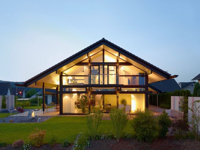 Helles Architektenhaus mit Glasfront und Gartenbeleuchtung