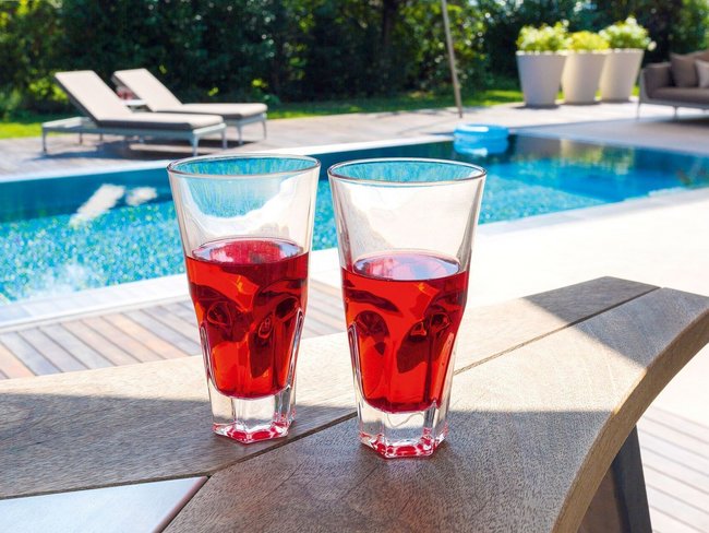 Zwei Gläser mit rotem Getränk auf einem Tisch neben dem Pool