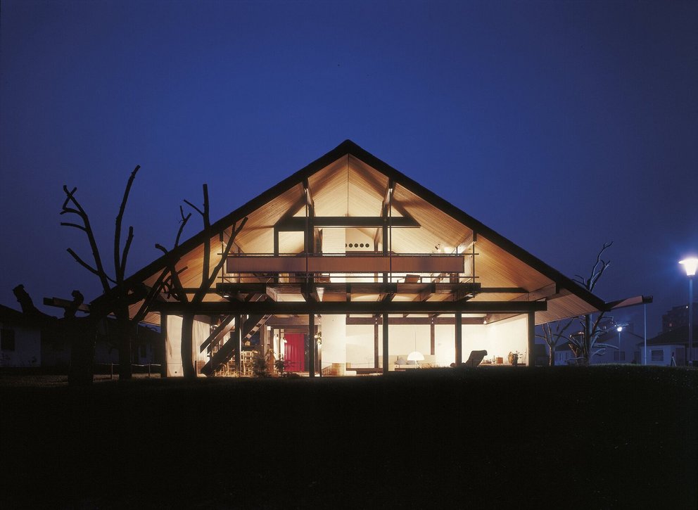 Modernes Haus mit schrägem Dach bei Nacht Architektonisches Design eines Hauses mit beleuchtetem Innenraum