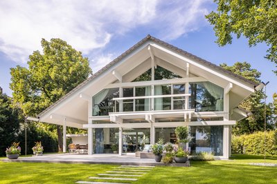 Modernes HUF Haus mit großen Fenstern und grünem Garten