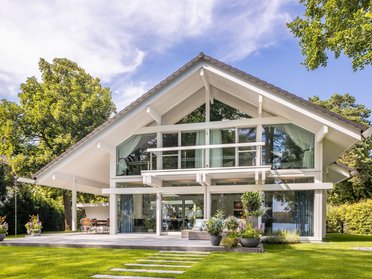 Modernes HUF Haus mit großen Fenstern und grünem Garten